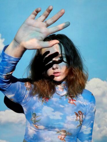 woman in blue and white floral long sleeve shirt wearing black sunglasses