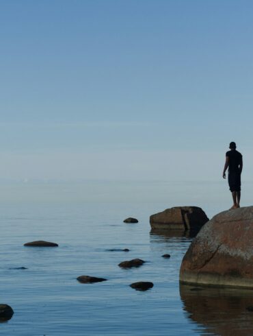 man standing on brown rock