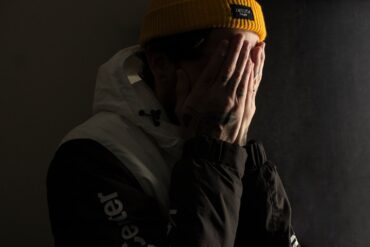 man covering his face with both hands