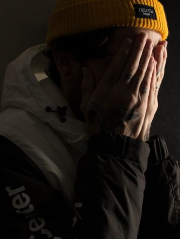 man covering his face with both hands