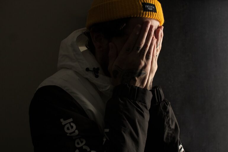 man covering his face with both hands