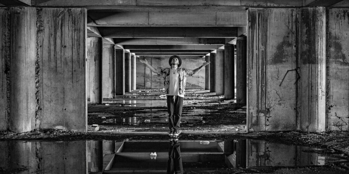 a man standing in a tunnel with his arms outstretched