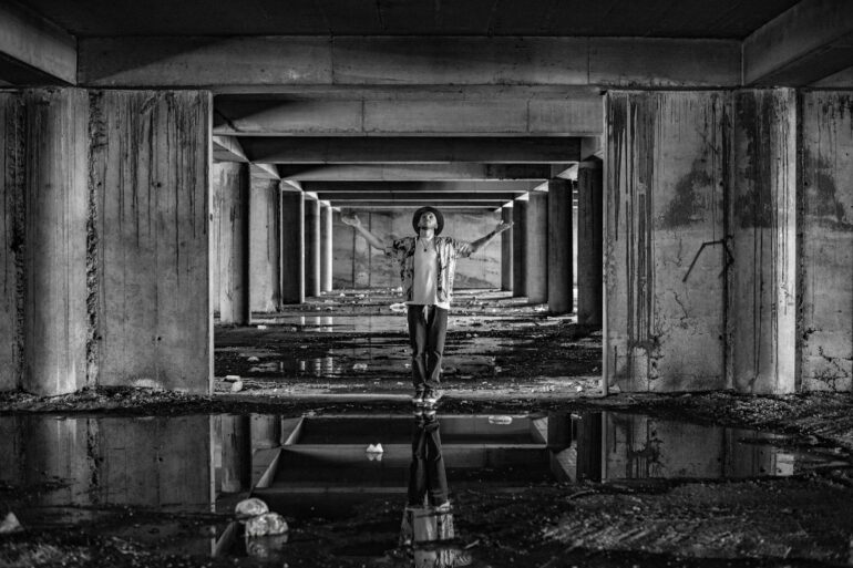 a man standing in a tunnel with his arms outstretched
