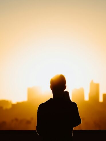 silhouette photography of standing person during sunset