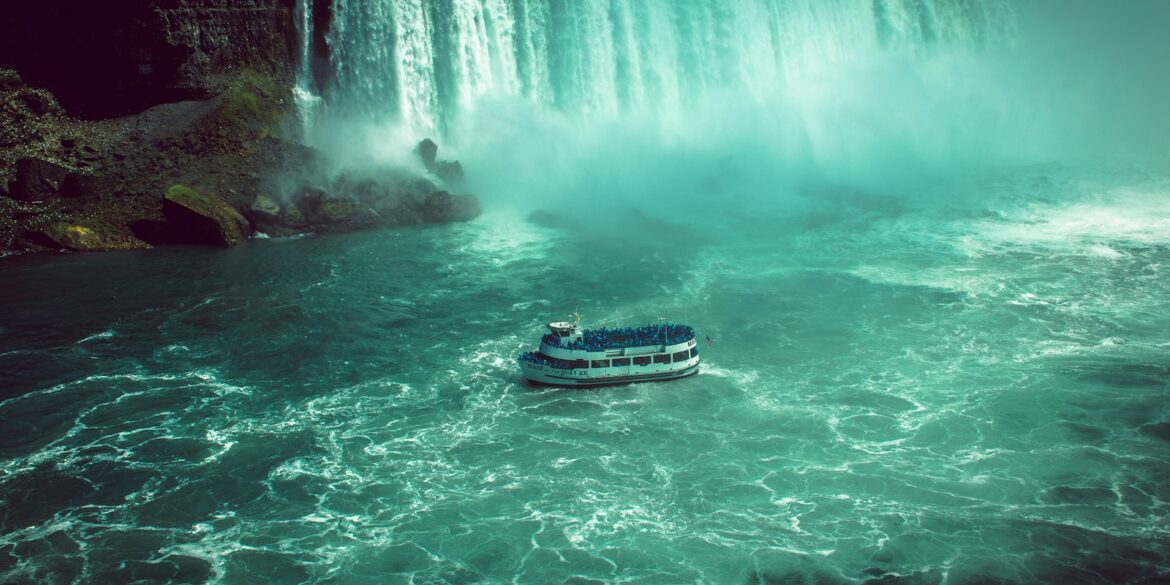 white and black boat on water falls