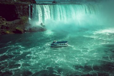 white and black boat on water falls