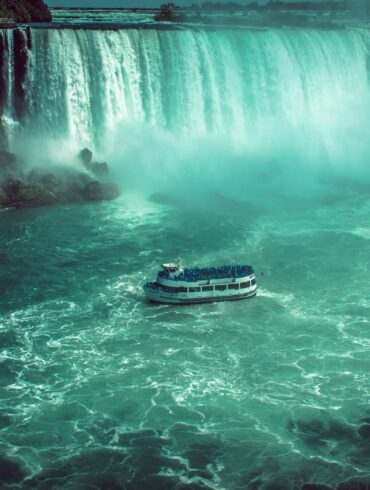 white and black boat on water falls