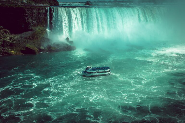 white and black boat on water falls