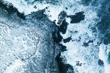 a bird's eye view of the ocean and rocks