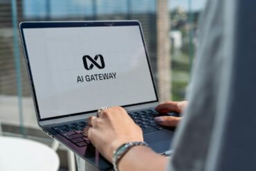 Person typing on laptop with ai gateway logo.