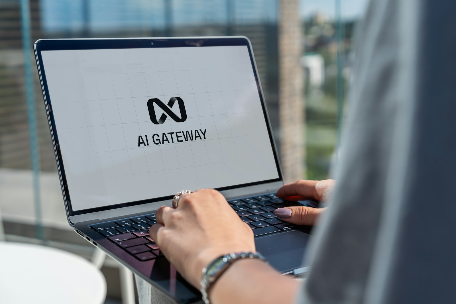 Person typing on laptop with ai gateway logo.