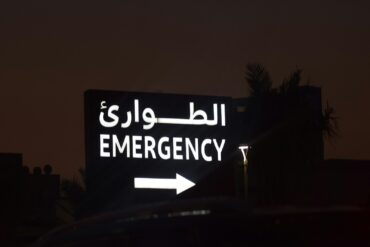 Emergency sign with arabic text and arrow