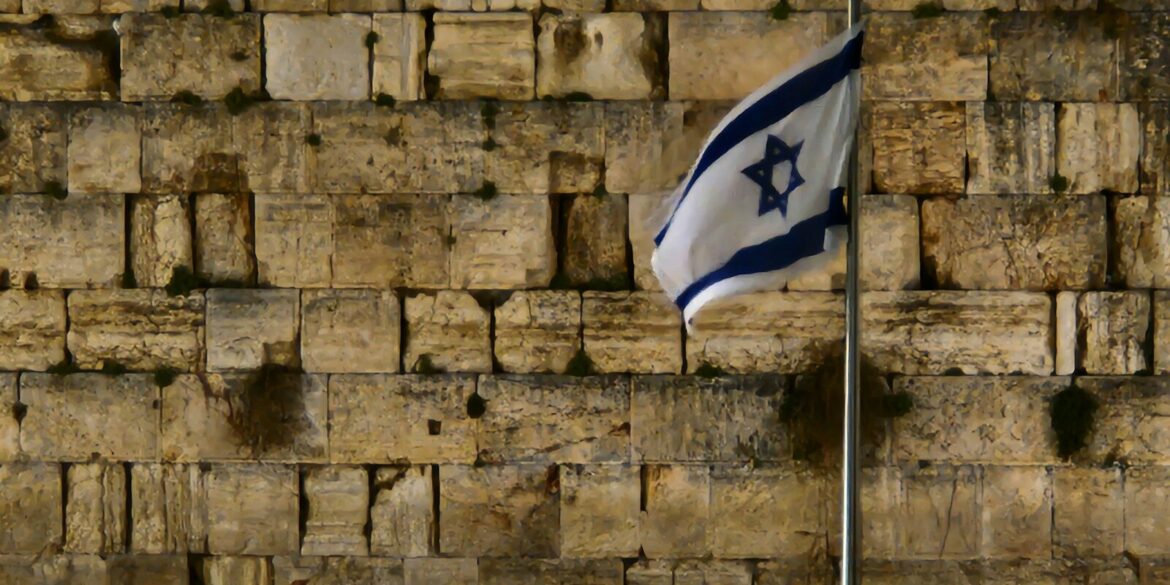 a flag is flying in front of a wall of bricks