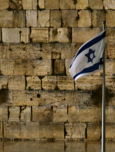 a flag is flying in front of a wall of bricks