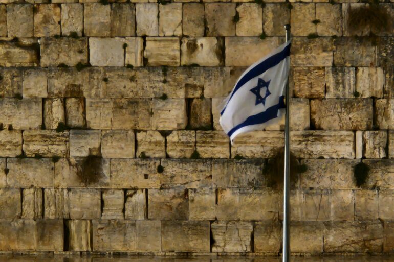 a flag is flying in front of a wall of bricks