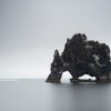 black rock formation on body of water