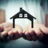 Hands holding a silhouette of a house