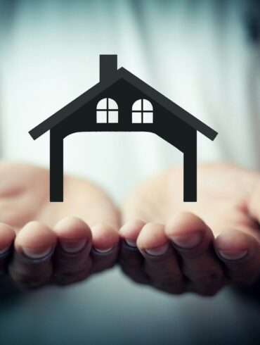 Hands holding a silhouette of a house