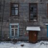 brown brick house with snow covered field