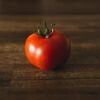 red tomato on brown wooden table