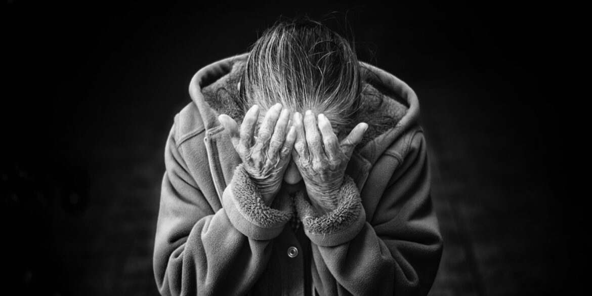 grayscale photography of person covering face