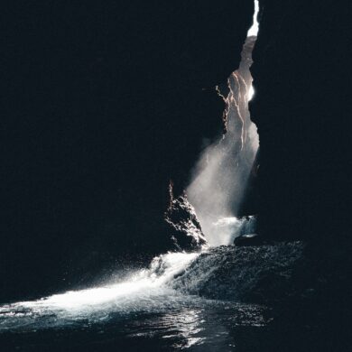 a large rock sticking out of a body of water