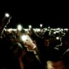 crowd holding smartphone while in flashlight