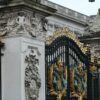 a black and gold gate with statues on it