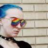 a woman with blue hair and rainbow glasses