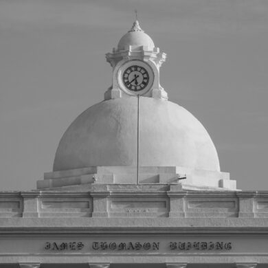 a black and white photo of a clock on top of a building